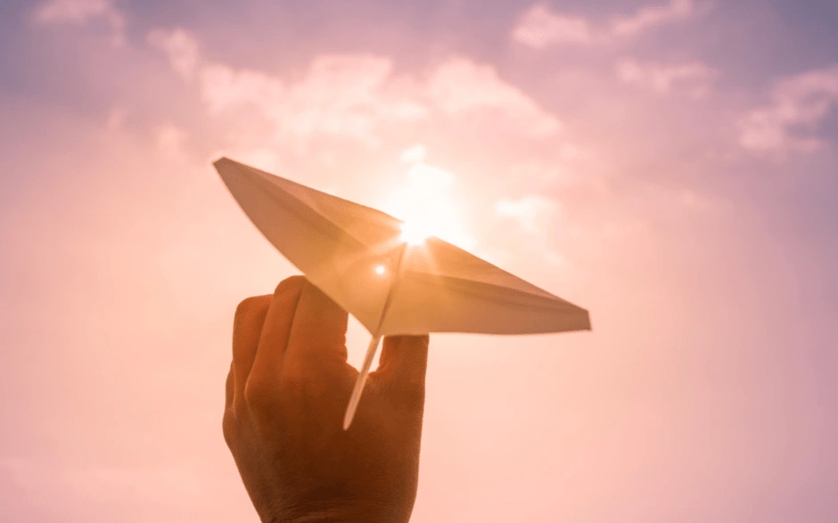 papier en avion en face de la lumière du soleil