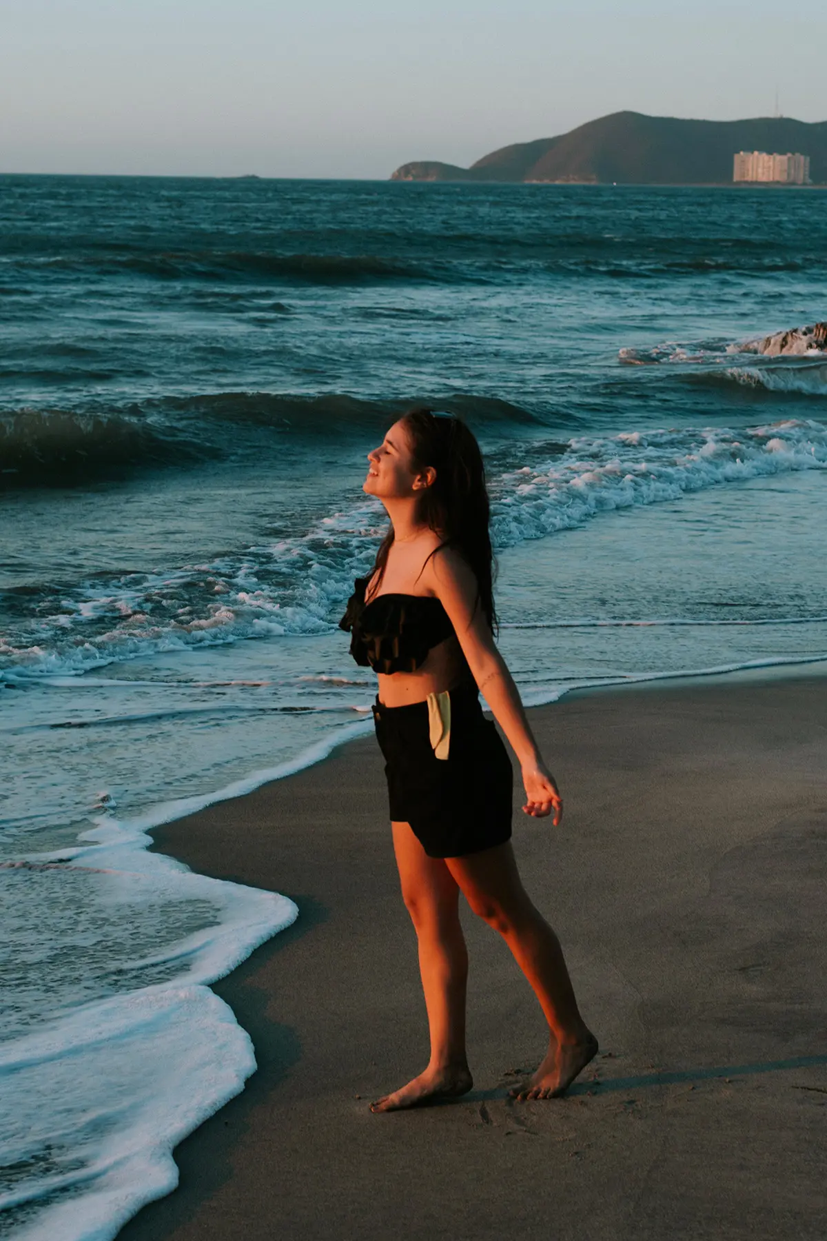 femme seule sur la plage en train de sourire 