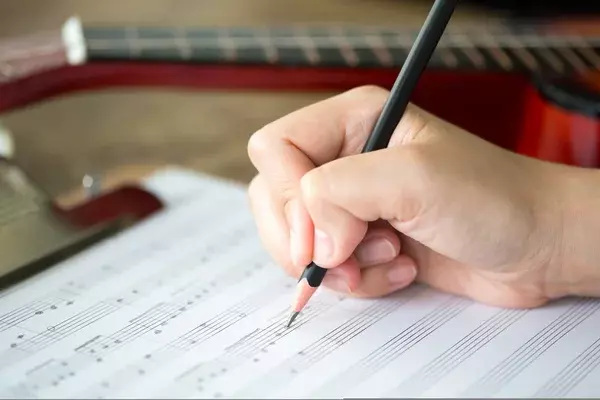 ecriture sur un cahier avec des notes musicales